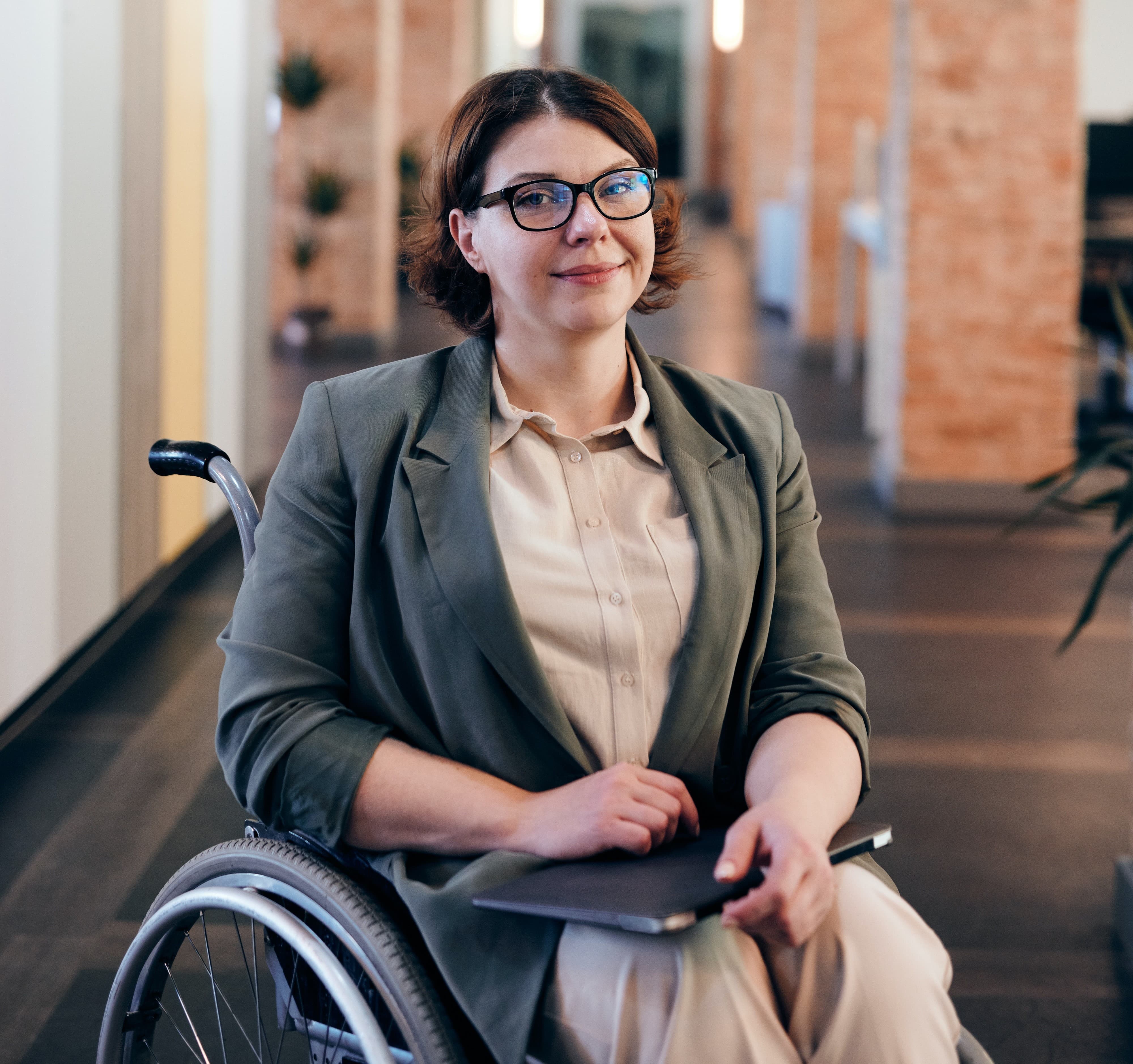 Image of a smiling business owner in a wheel chair with her laptop.
