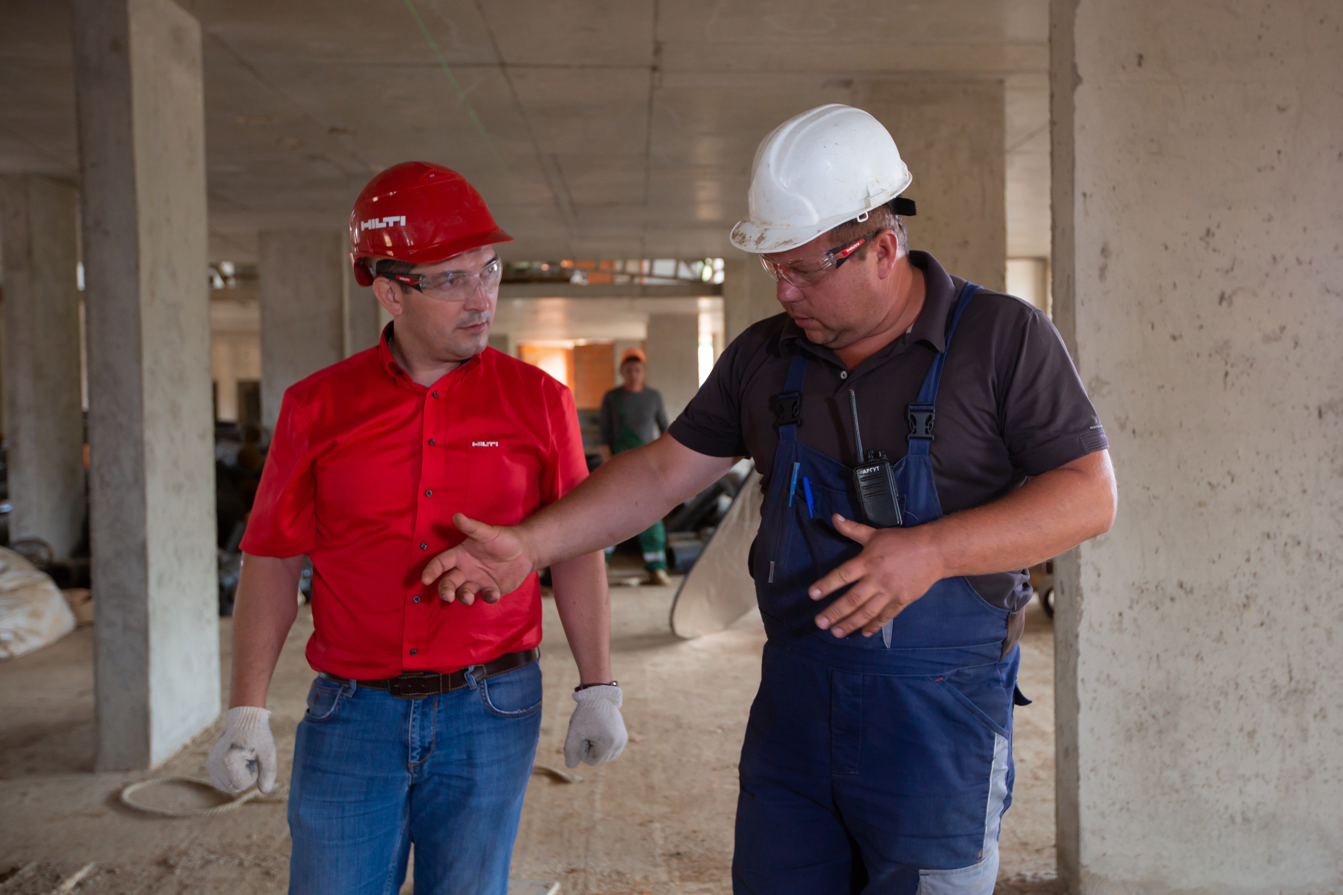 Image of two senior construction workers discussing business.